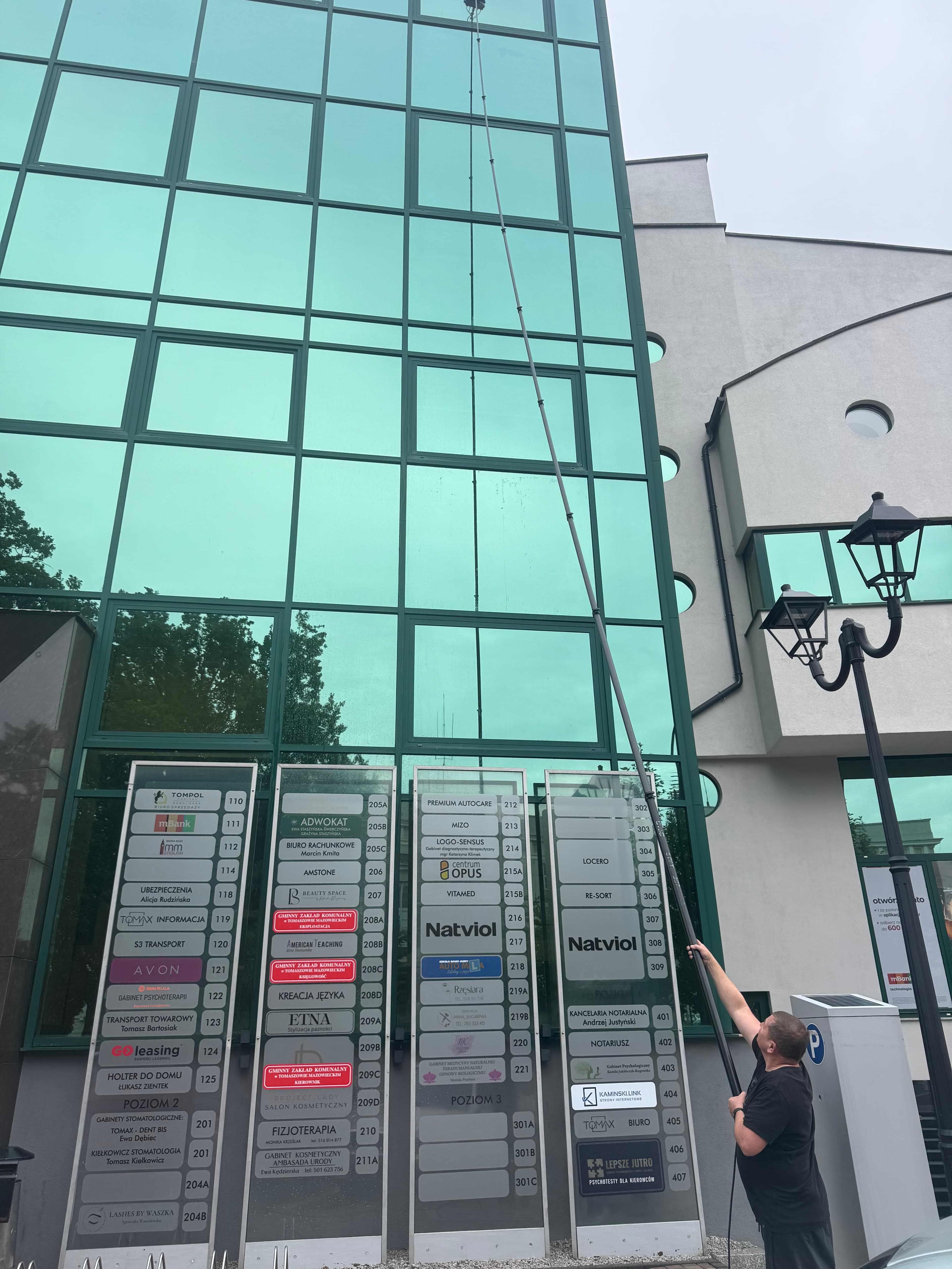 Mycie szyb w biurowcu za pomocą teleskopu